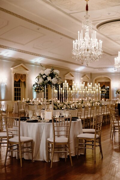 A wedding reception set up with tables covered in tall candles 