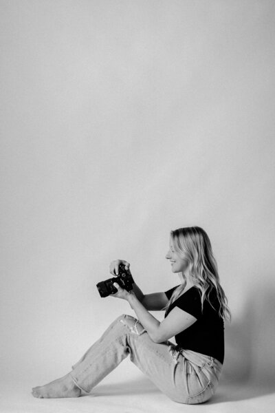 black and white photo of girl holding camera