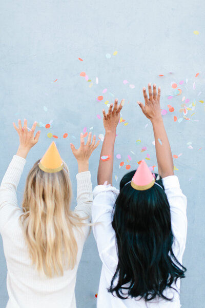 An image of two women throwing confetti in the air in celebration stock image for systems and workflow  educator Dolly DeLong Education