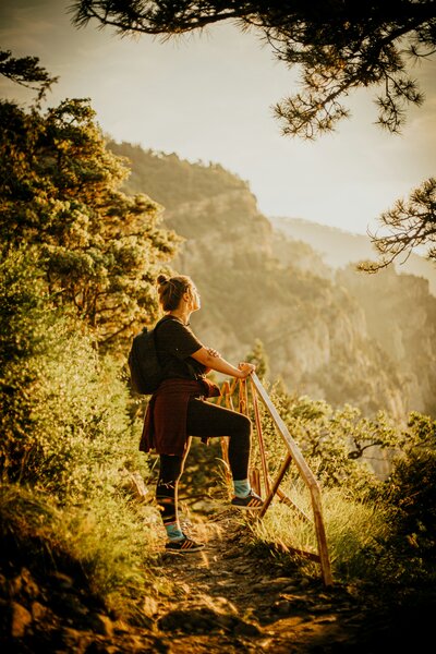 woman on hike looking out into forest