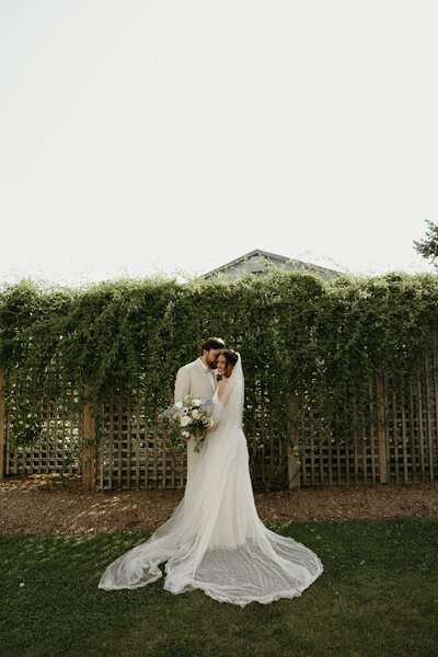 Intimate wedding portrait of a bride and groom sharing a quiet moment together in an outdoor setting