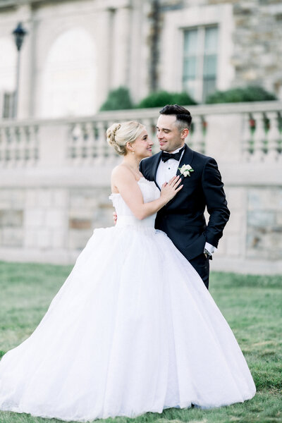 Bride and groom pose oceanside outside of Aldrich Mansion in Warwick Rhode Island