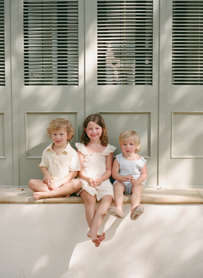 Film photo three young siblings sitting together 