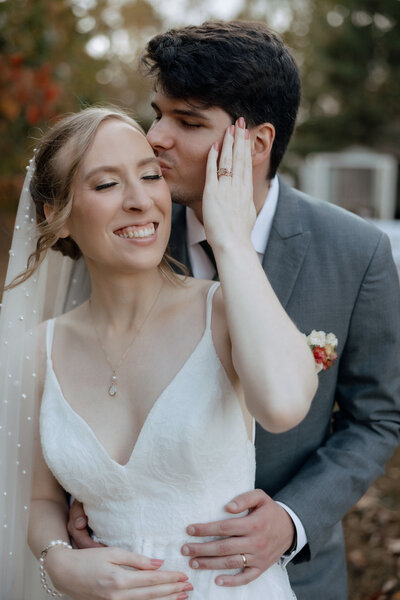 A newlywed husband and wife hold hands while walking through the gardens at the River Road and Jasmine House in Columbia, South Carolina. They're smiling at each other.