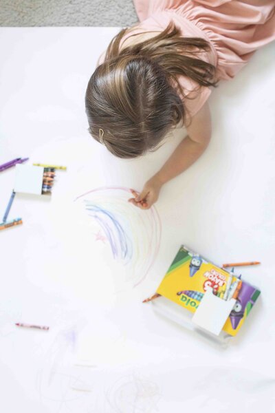 Child coloring on white posterboard