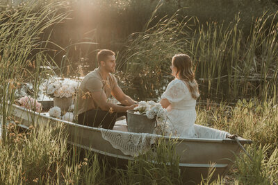 photo of couple sitting in a rowboat