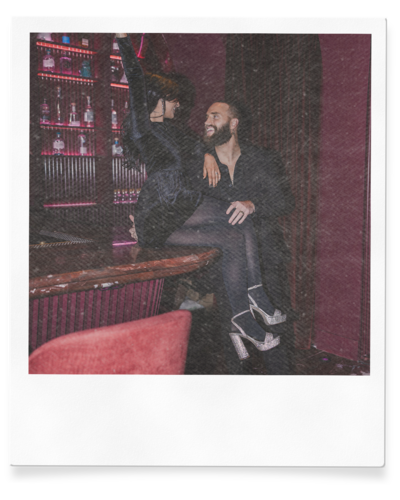 couple sits on bar during engagement photo session in las vegas