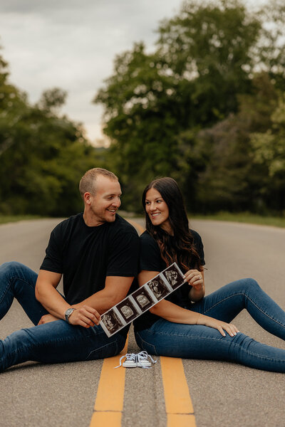 maternity photoshoot with woman kissing  in field