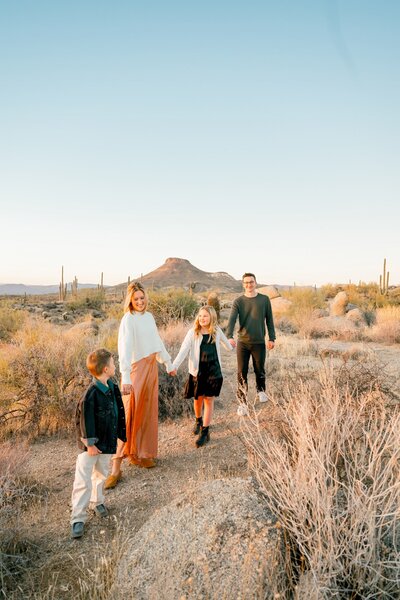 family walking in the desert holding hands 