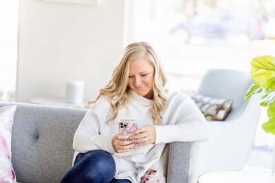 Kacey Wyrick, photographer minneapolis, looking at phone on the couch