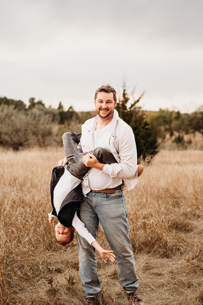 A dad has a fun and silly moment with one of his kiddos while taking family pictures at Sweet Briar Lake, just west of Mandan, ND.