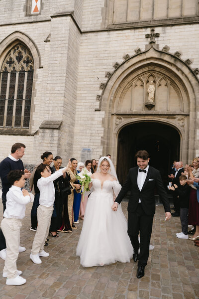 Bruidspaar komt uit de kerk gelopen na huwelijk in de kerk.