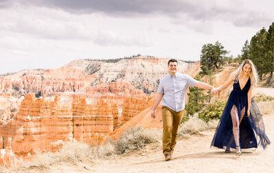 bride and groom sitting on rocks with Lake superior in the background and tall, green, pine trees