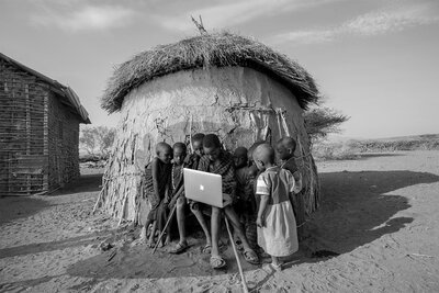 Boys working on laptop in remote african village