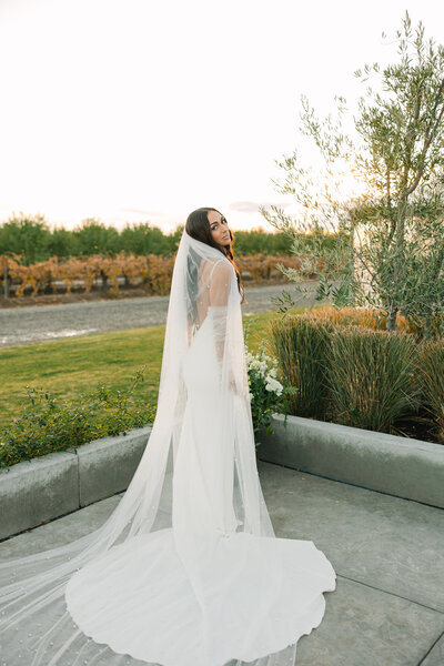 bride looking over her shoulder holding a bouquet