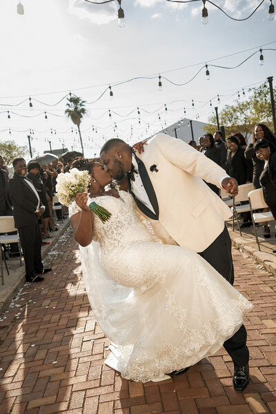 black newlyweds dip and kiss at outdoor ceremony documentary 