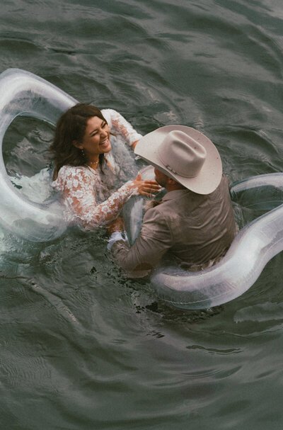 bride and groom laughing together in the water at their elopement captured by a PNW elopement photographer