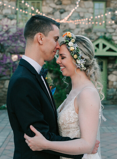 Bride and groom standing close together in the courtyard of Willowdale Estate, captured by Ari Leo of Ari Marie Photography, a Boston wedding photographer