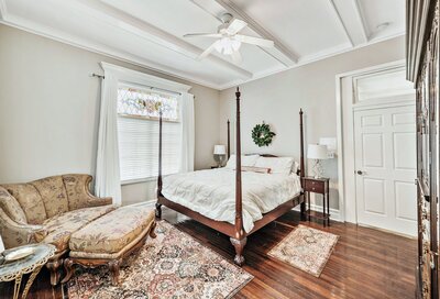 4 poster bed and stained glass window in a historic vacation rental home in downtown Waco, TX