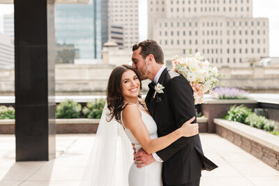 Bride and groom posing in front of Indianapolis Skyline