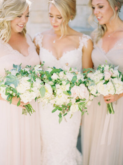 Seattle Wedding Photographers -bridesmaids holding flowers together in pink gowns 