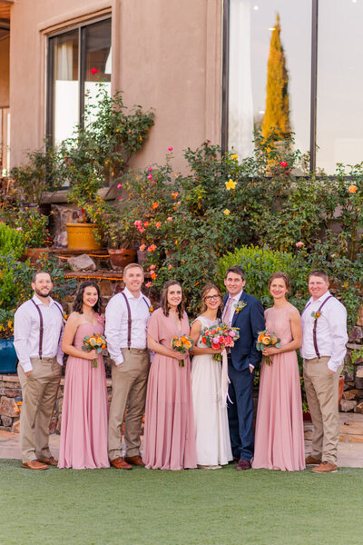 bridal party in blush colored outfits at wedding