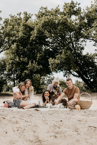 Gezin op een picknickkleed bij de Zeegser Duinen tijdens een gezinsshoot