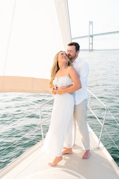 Newport Wedding Photographer | Rhode Island Caprio Captured Photography | Couple is kissing while embracing an engagement session in a sailboat in Newport, RI