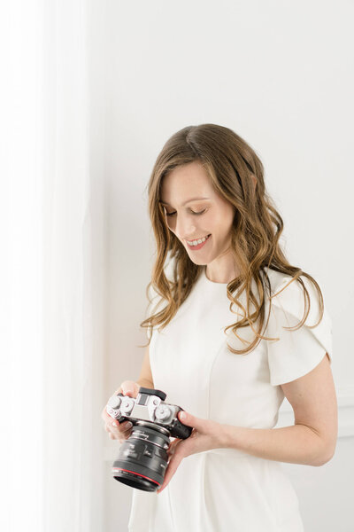 Charlottesville Wedding Photographer Bethany Aubre Photography looking at her camera.