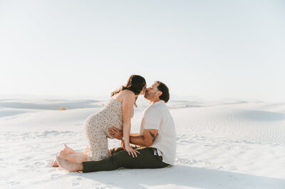 couple sitting down holding each other at White Sands