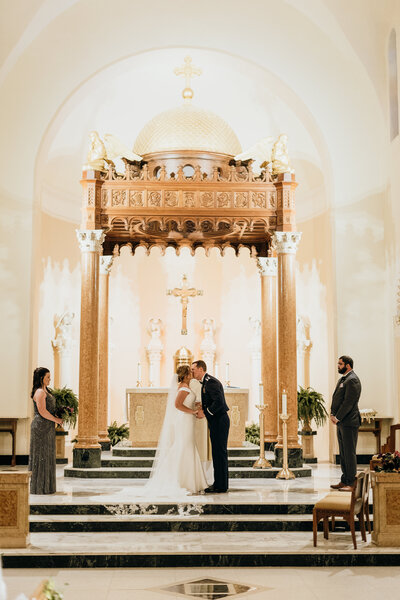 bride and groom  kissing in church