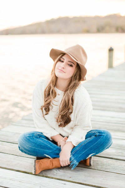 high school senior sitting on dock during senior session with costola photography