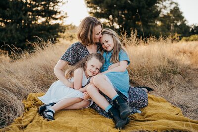 seattle-mom-snuggling-with-daughters-at-park