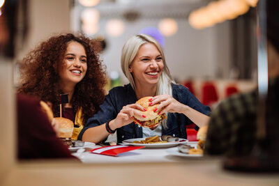 women smiling and laughing while eating in a quick-service restaurant 