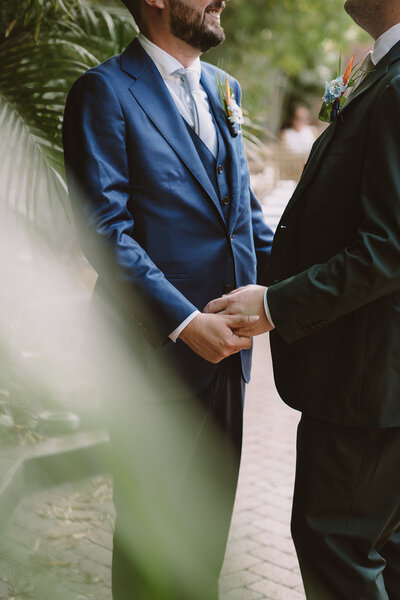 grooms holding hands queer wedding