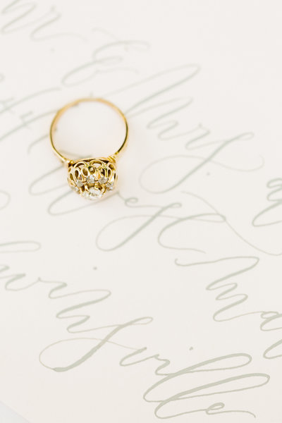 gold engagement ring sitting on invitation during philadelphia pa wedding