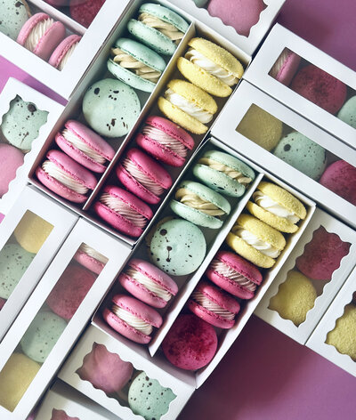colorful homemade macarons packed into to-go boxes
