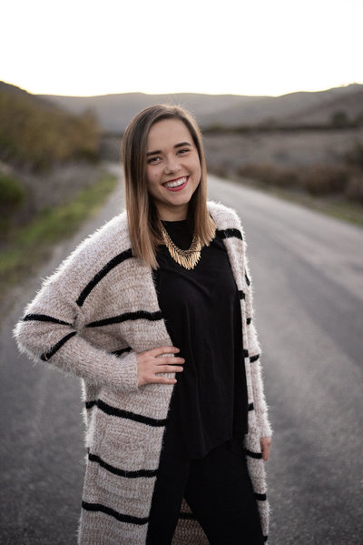 Melissa from Three16 Photography poses on a highway during photo session