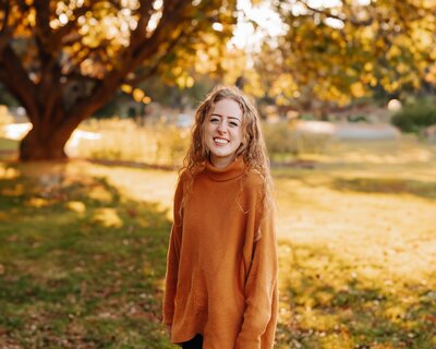 Mack smiling in an orange sweater