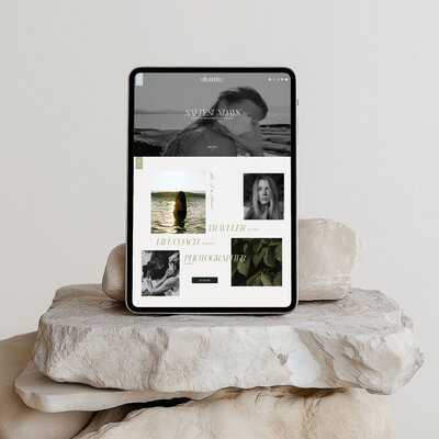 A tablet mockup with a soulful designs studio website standing on beige big stones