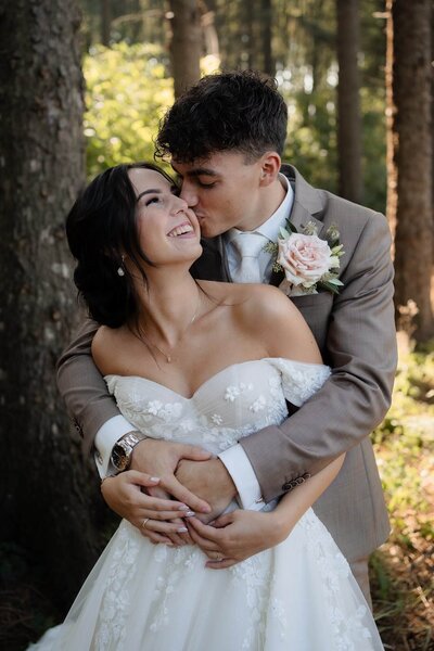 Bruid en bruidegom in bos tijdens fotoshoot op hun trouwdag, gefotografeerd door trouwfotograaf Julia de Groot