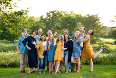 Extended family close together doing silly poses. 