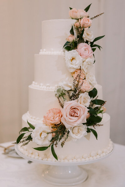 4 Tiered wedding cake from Mayflour with flowers draped down the side
