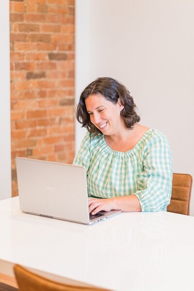 Renee sitting at computer in Bowling Green, Kentucky during brand session