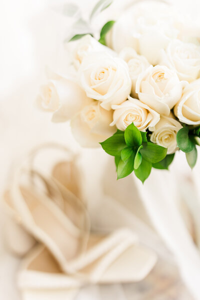 Close-up of elegant white roses and pristine white wedding shoes from a Montrose, Colorado wedding, highlighting refined details and timeless beauty