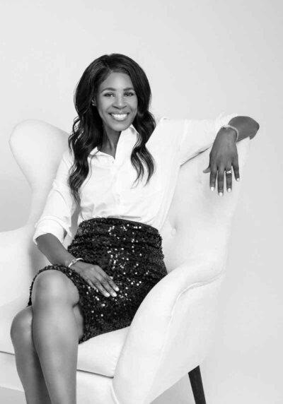 Elegant black and white portrait of a woman in a white blouse and sequin skirt. 