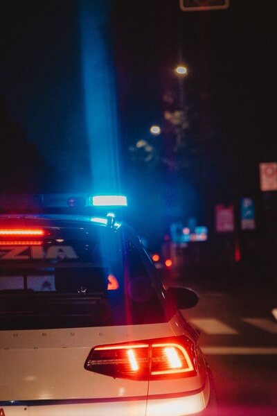 The back of a police car with the blue and red lights flashing