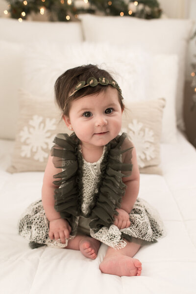 Baby girl wrapped in blush on white bed