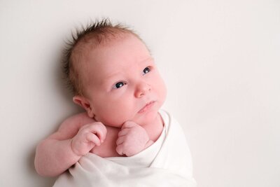 Baby in een ontspannen pose, gefotografeerd door Newborn Fotograaf Tilburg. Newbornshoot thuis.