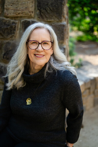 Audrie Meyer smiling warmly, offering a blend of psychotherapy and spiritual coaching to help heal trauma.